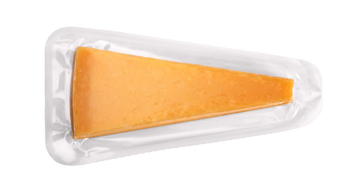 A wedge of orange cheddar cheese sealed in clear plastic packaging, displayed on a plain white background.