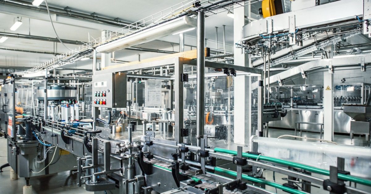 An industrial factory interior with metal equipment and machinery arranged throughout a production facility.